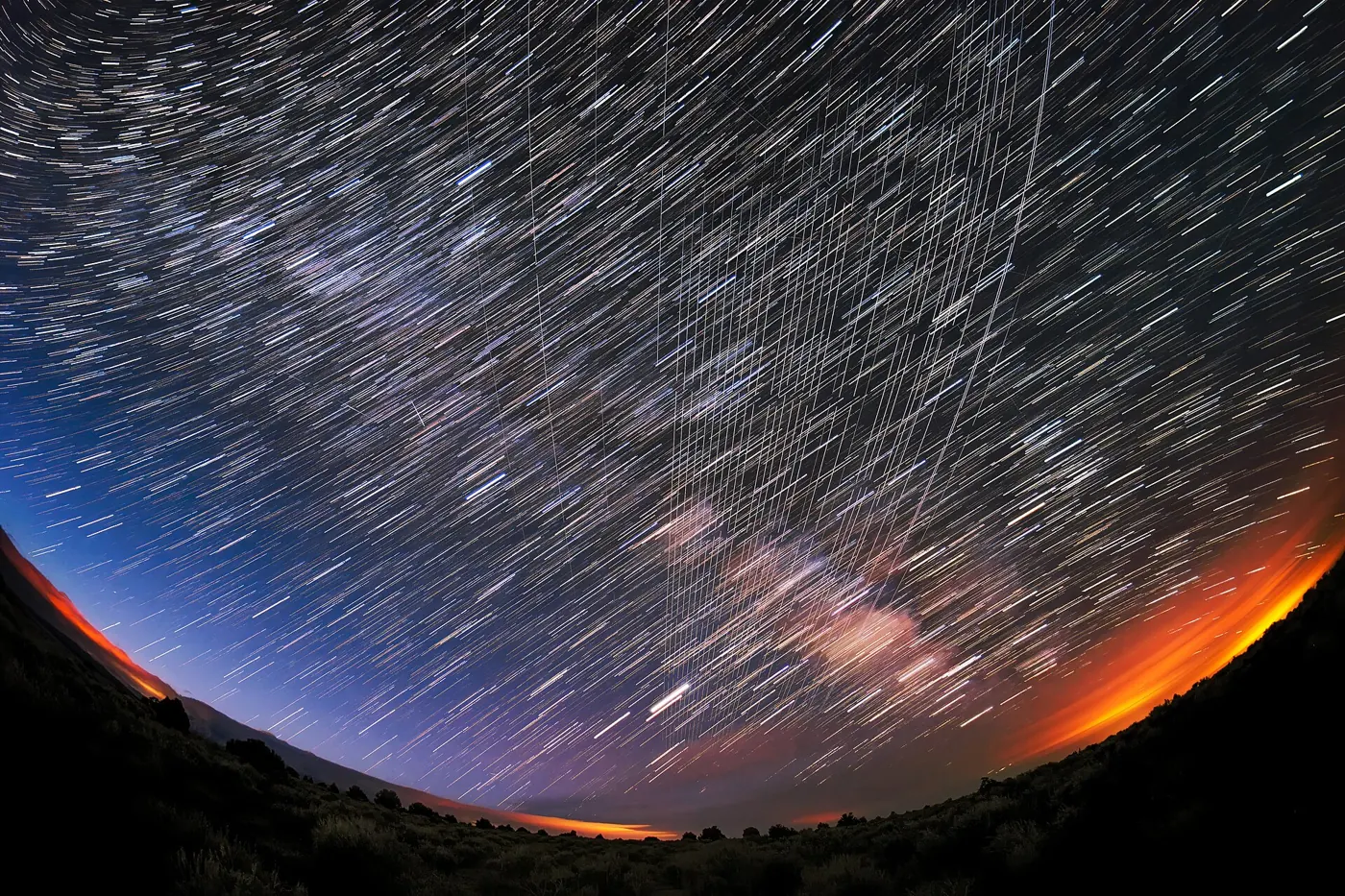 Long-exposure photo of Starlink satellites streaking across a night sky